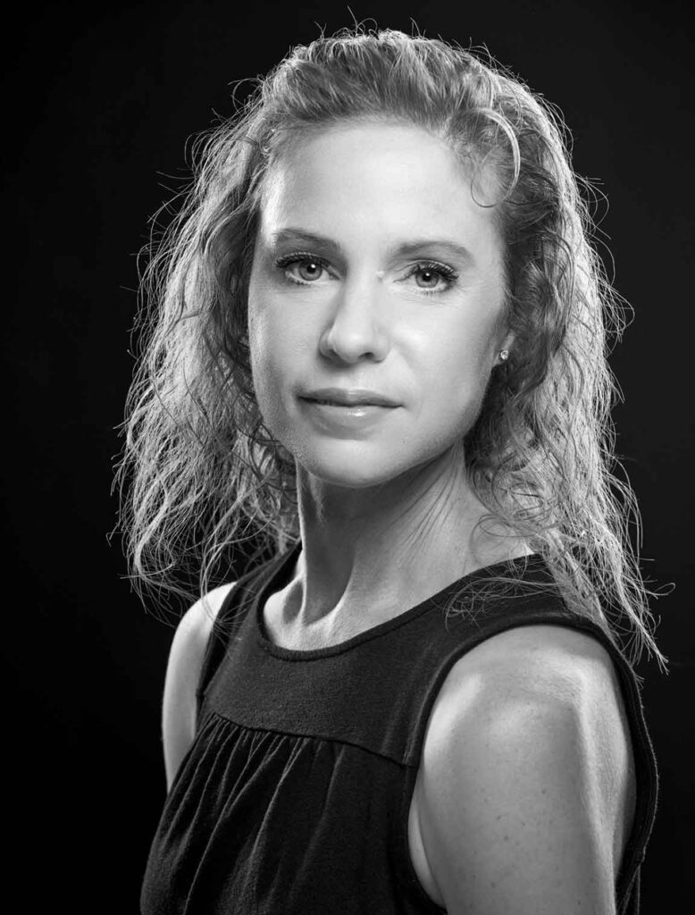 A black and white portrait of Sada Popick-Ogburn, Ballet Idaho Academy Administrator, wearing a sleeveless top.